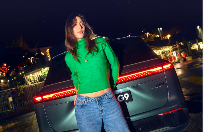 Woman in front of a car in the night doing a photo shoot