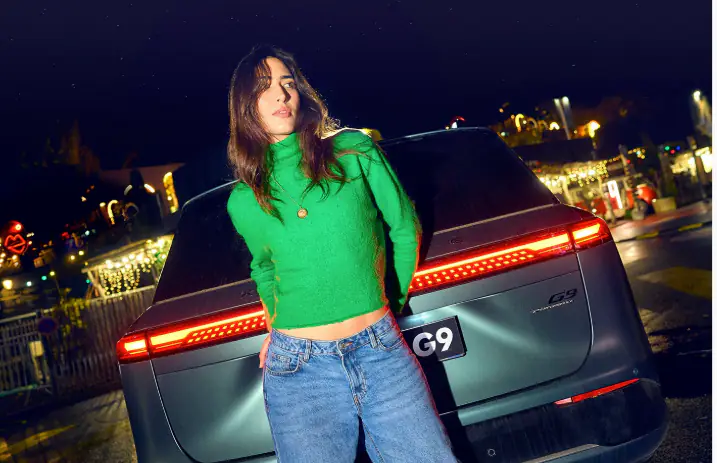 Woman in front of a car in the night doing a photo shoot